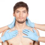 hands in blue gloves hold attractive young male face